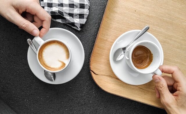 to kopper espresso og hænder der holder dem